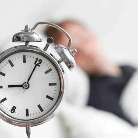 man sleeping with alarm clock