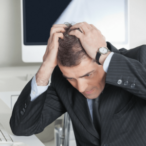 man pulling his hair considering surgical vs non surgical hair replacement treatments