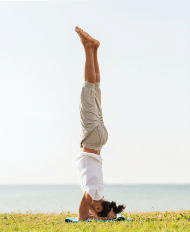 Man with thick hair yoga on beach 